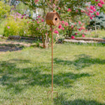 Decorative garden stake with a birdhouse on a grassy lawn