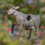 Metallic donkey-shaped object hanging against a blurred natural background