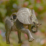 Decorative elephant ornament with leaf-shaped ears against a blurred natural background