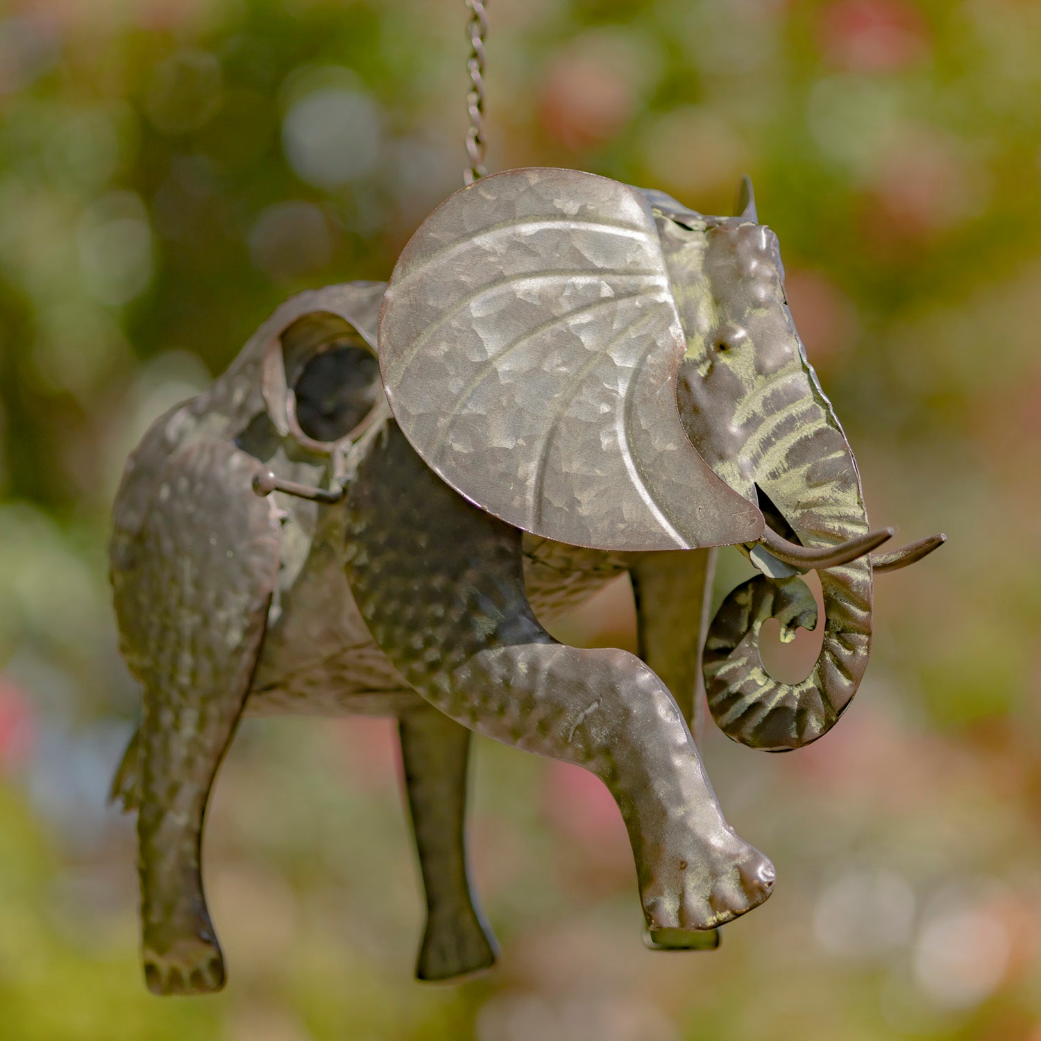 Decorative elephant ornament with leaf-shaped ears against a blurred natural background
