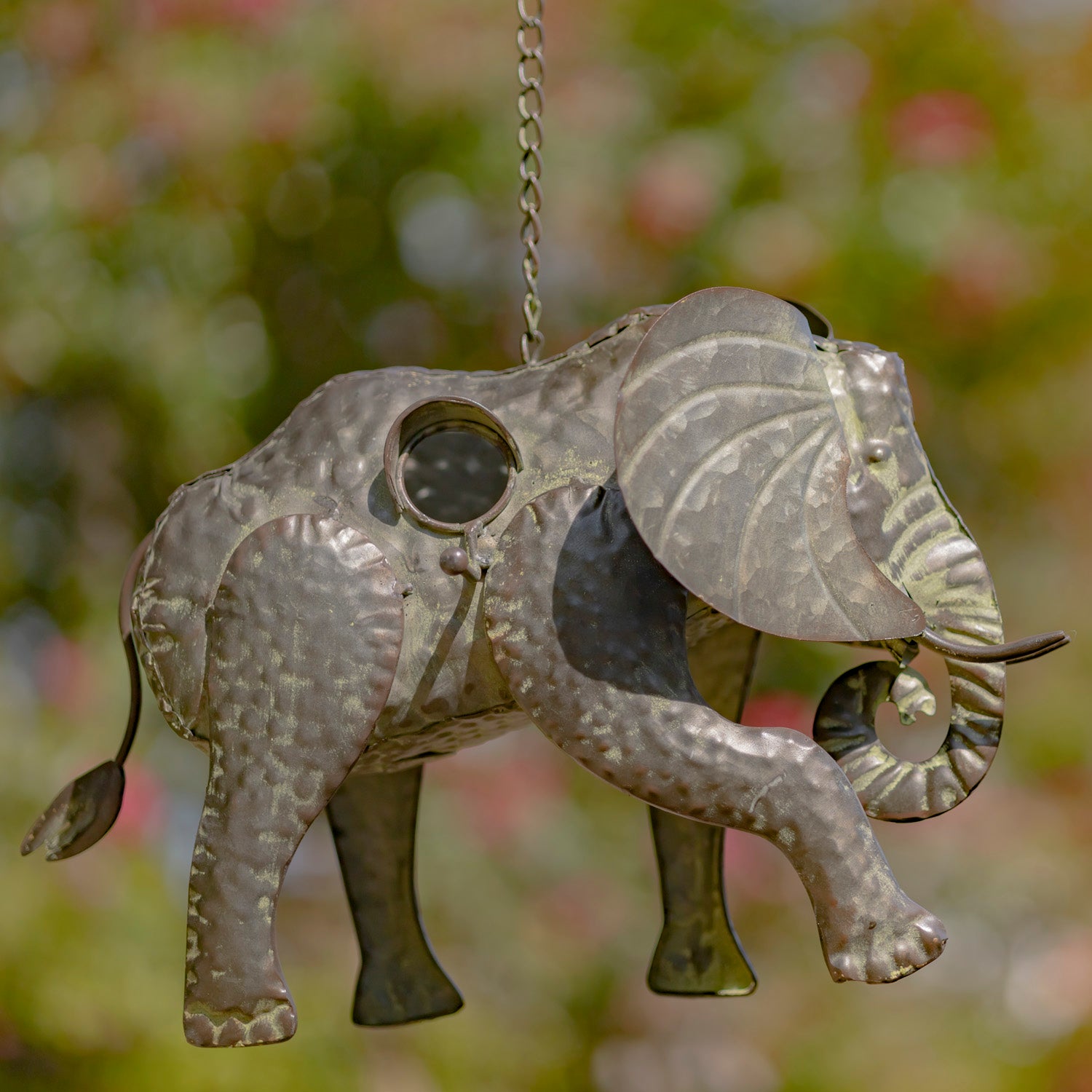 Decorative metal elephant hanging ornament with a blurred natural background