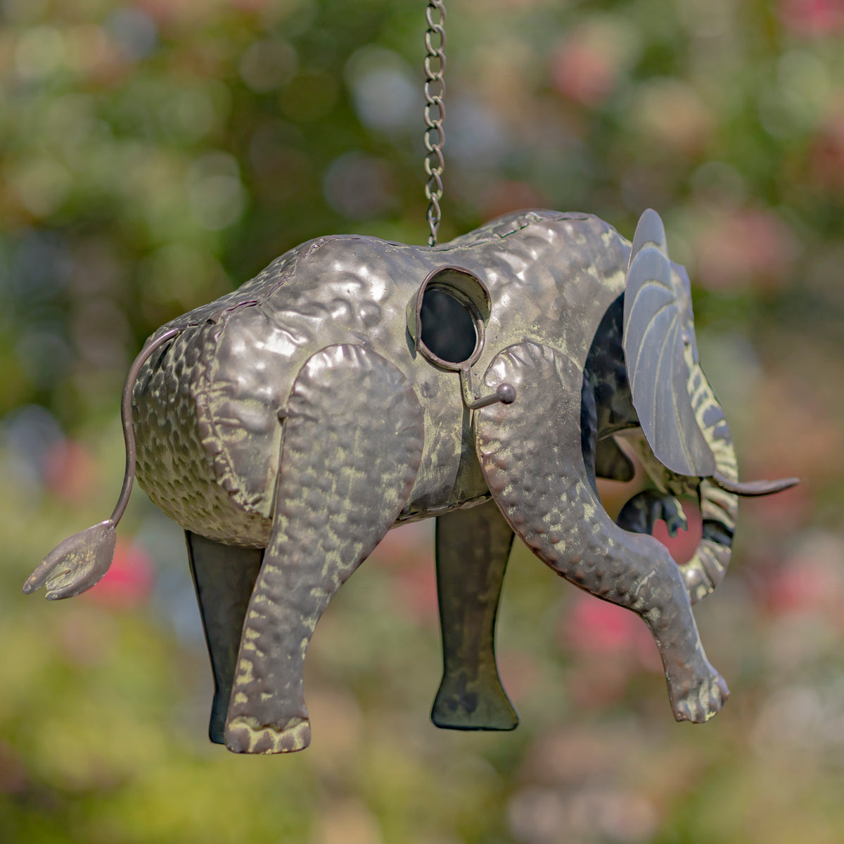Decorative elephant ornament hanging against a blurred natural background