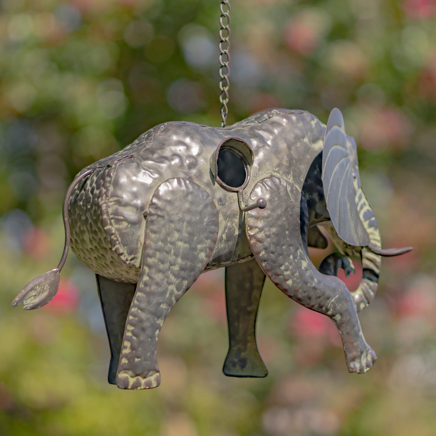 Decorative elephant ornament hanging against a blurred natural background