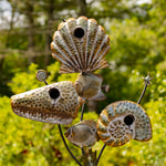 Decorative metal sculpture of seashells with a blurred green background