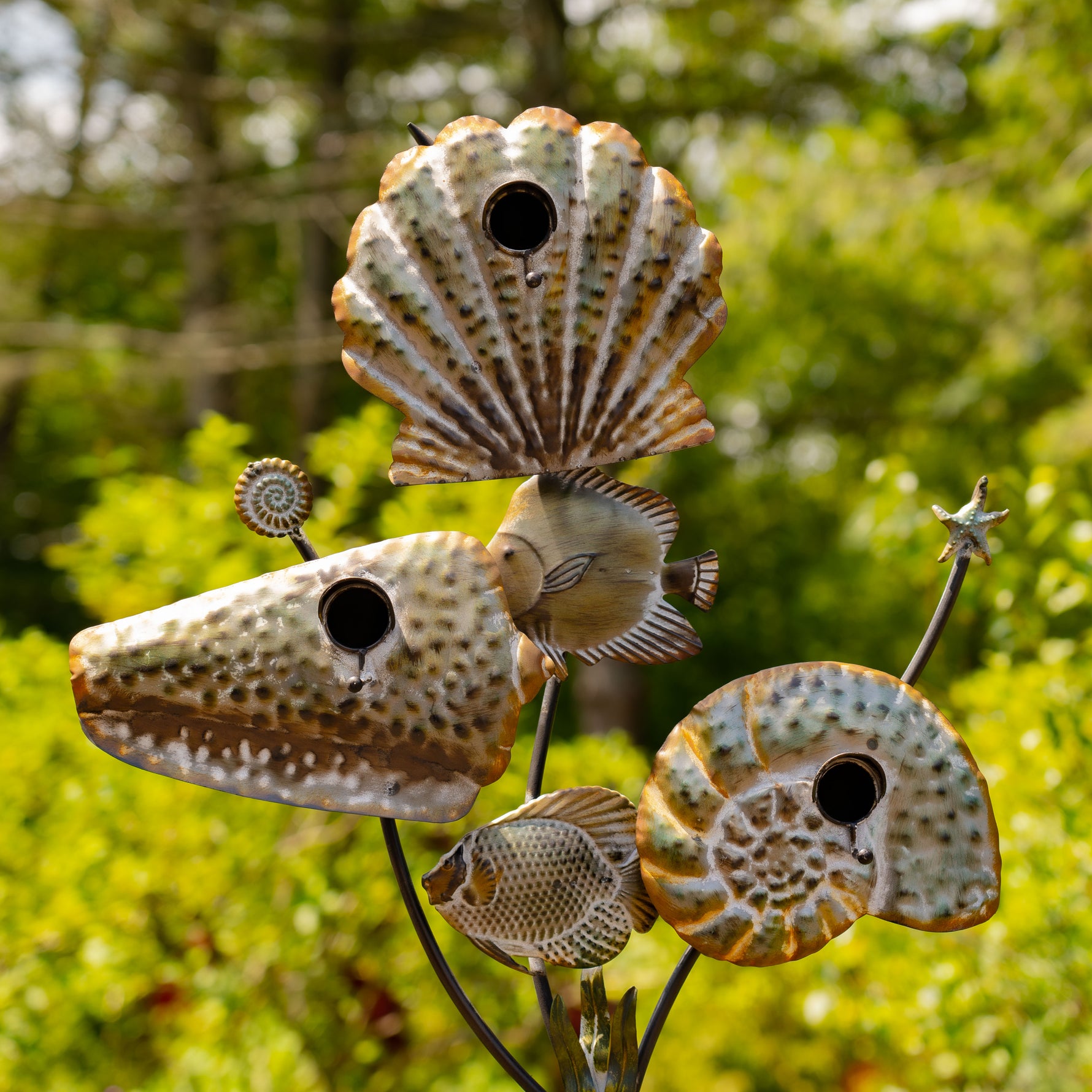 Decorative metal sculpture of seashells with a blurred green background