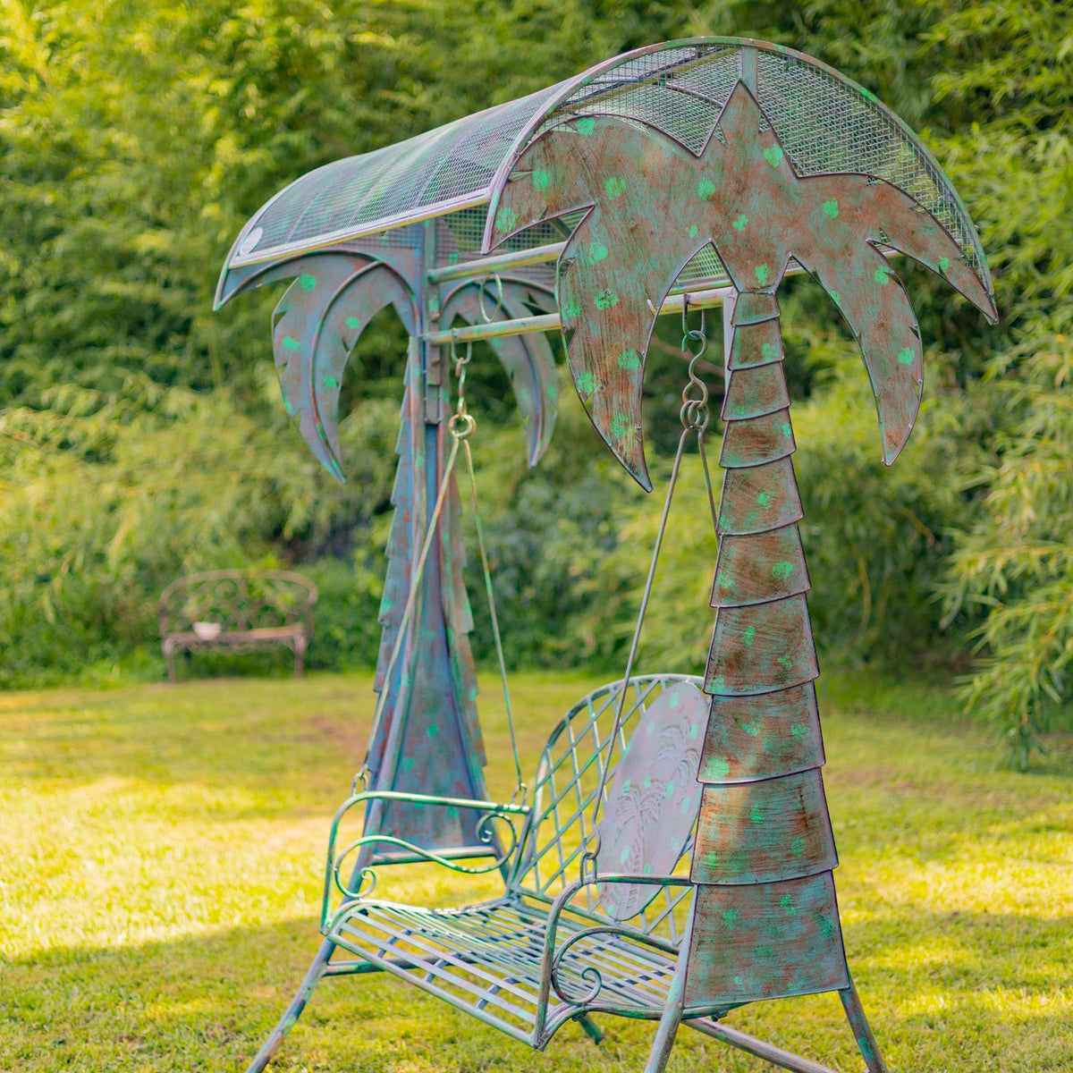 Metal swing with palm tree design in a garden setting