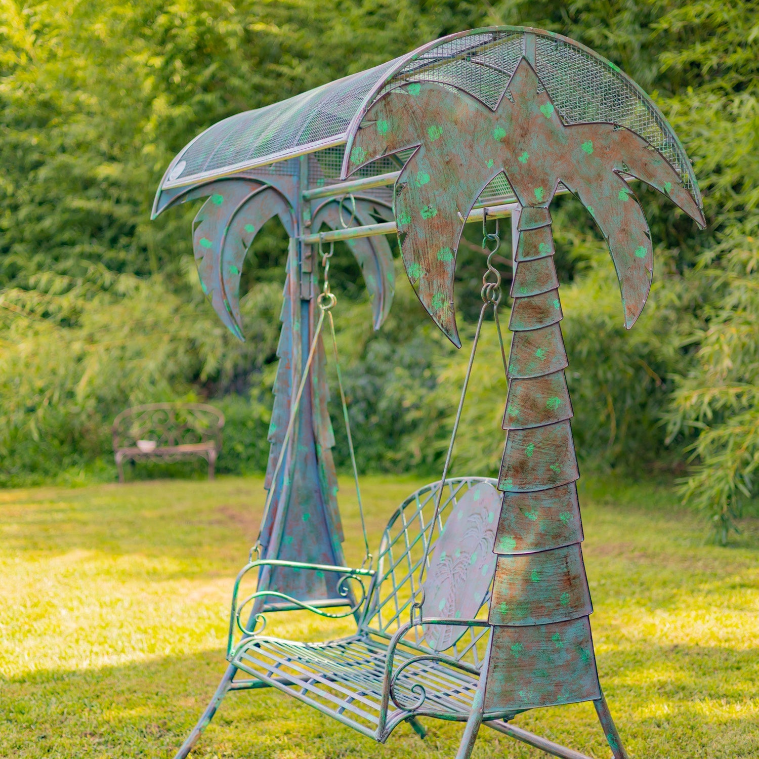Metal swing with palm tree design in a garden setting