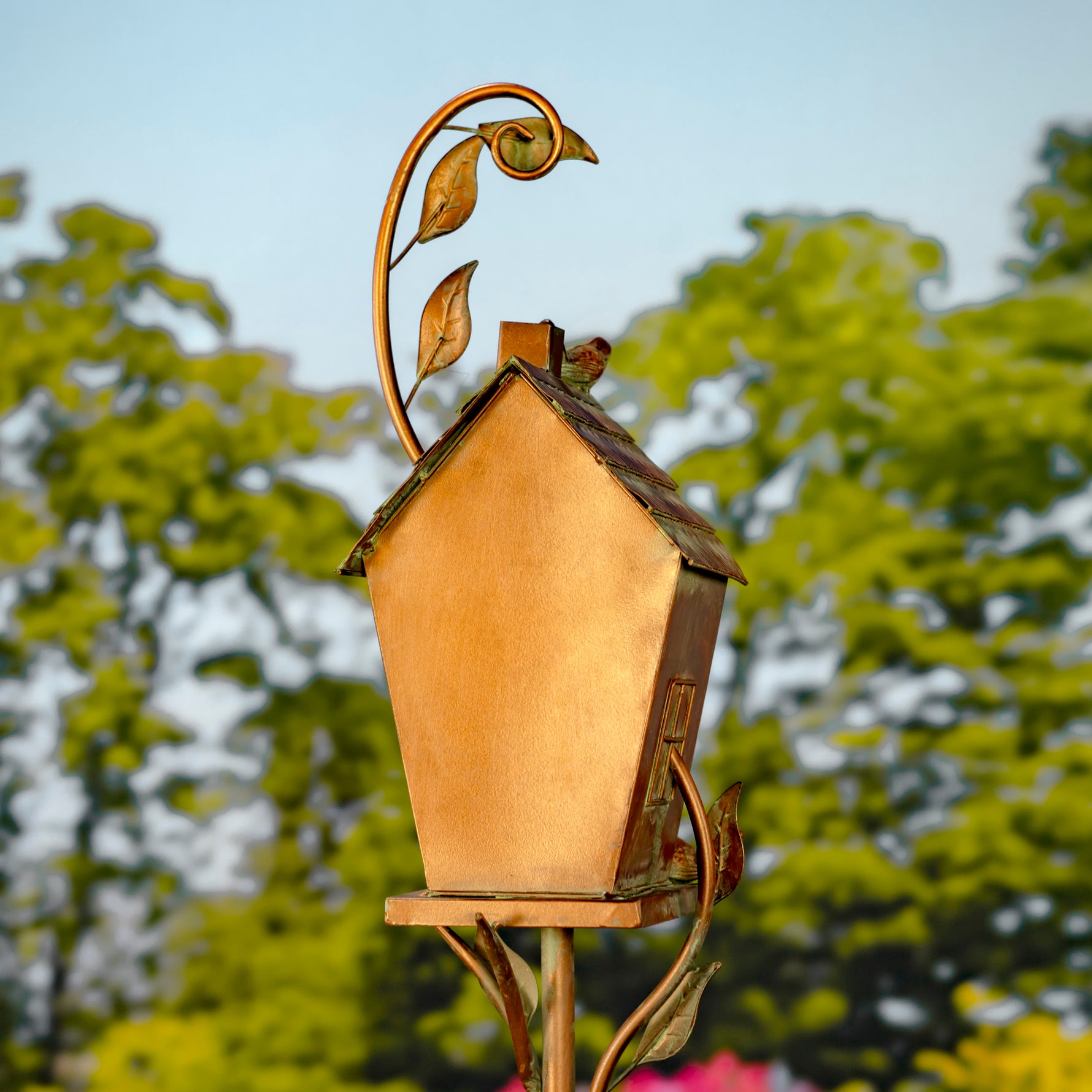 Decorative birdhouse with leaf design on a blurred natural background