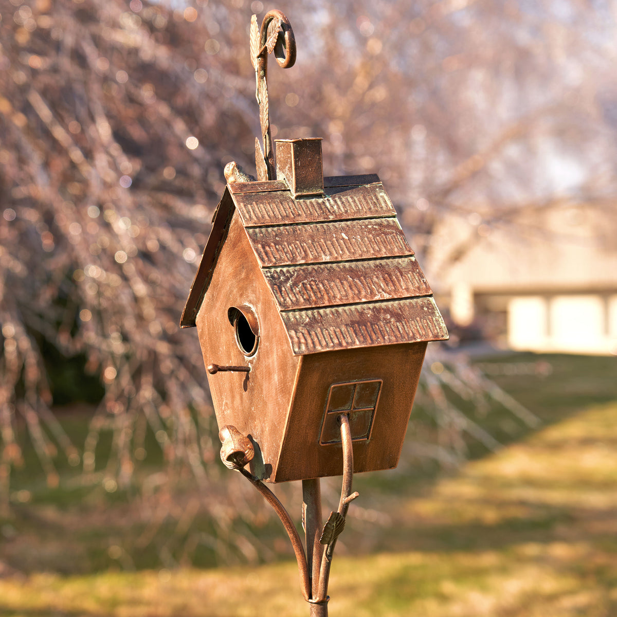 Wooden birdhouse on a stand with a blurred garden background