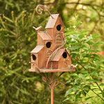 Decorative birdhouse on a stand with a garden background