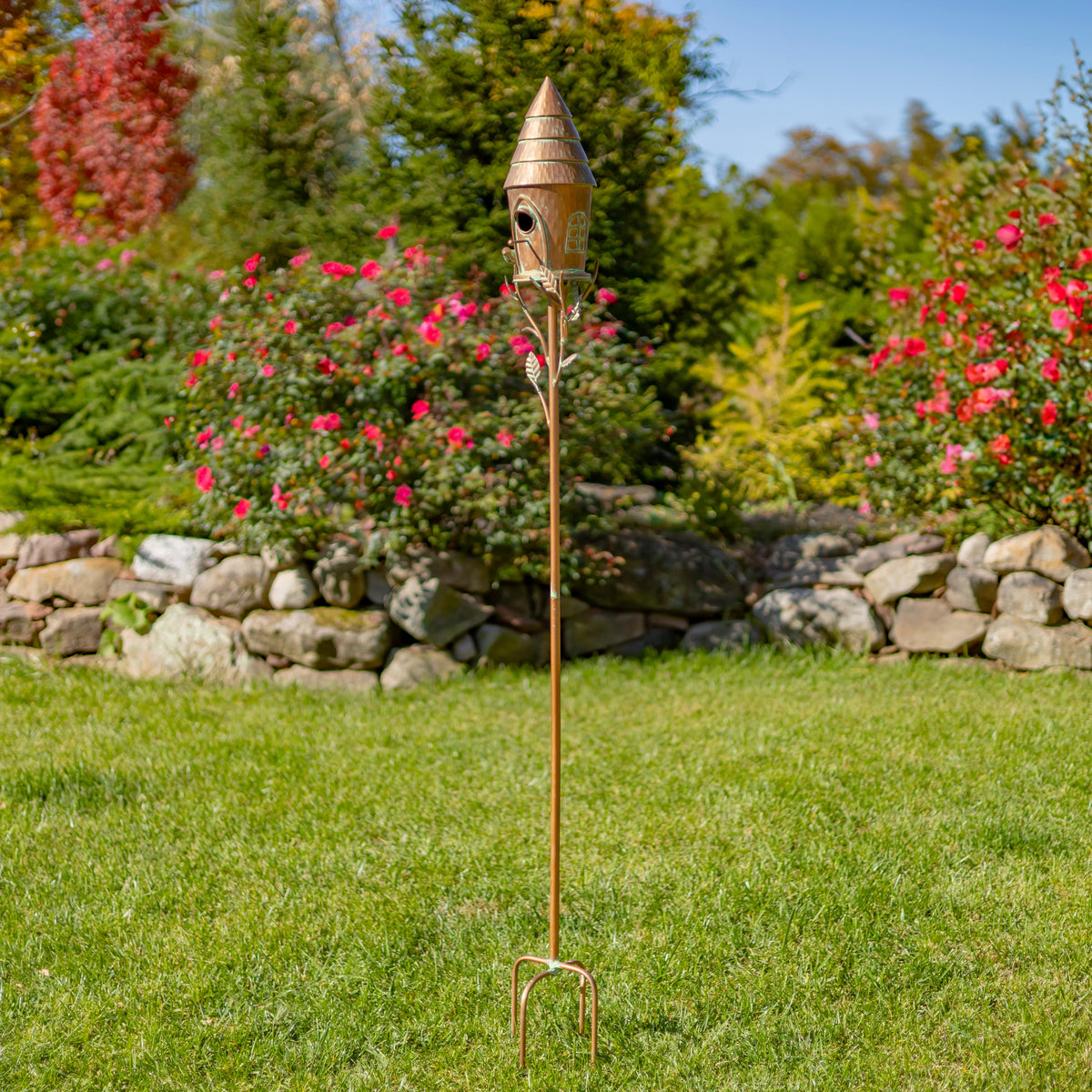Decorative garden stake with birdhouse in a garden setting