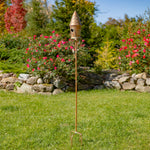 Decorative garden stake with birdhouse in a garden setting