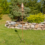 Decorative garden stake with birdhouse on a grassy lawn