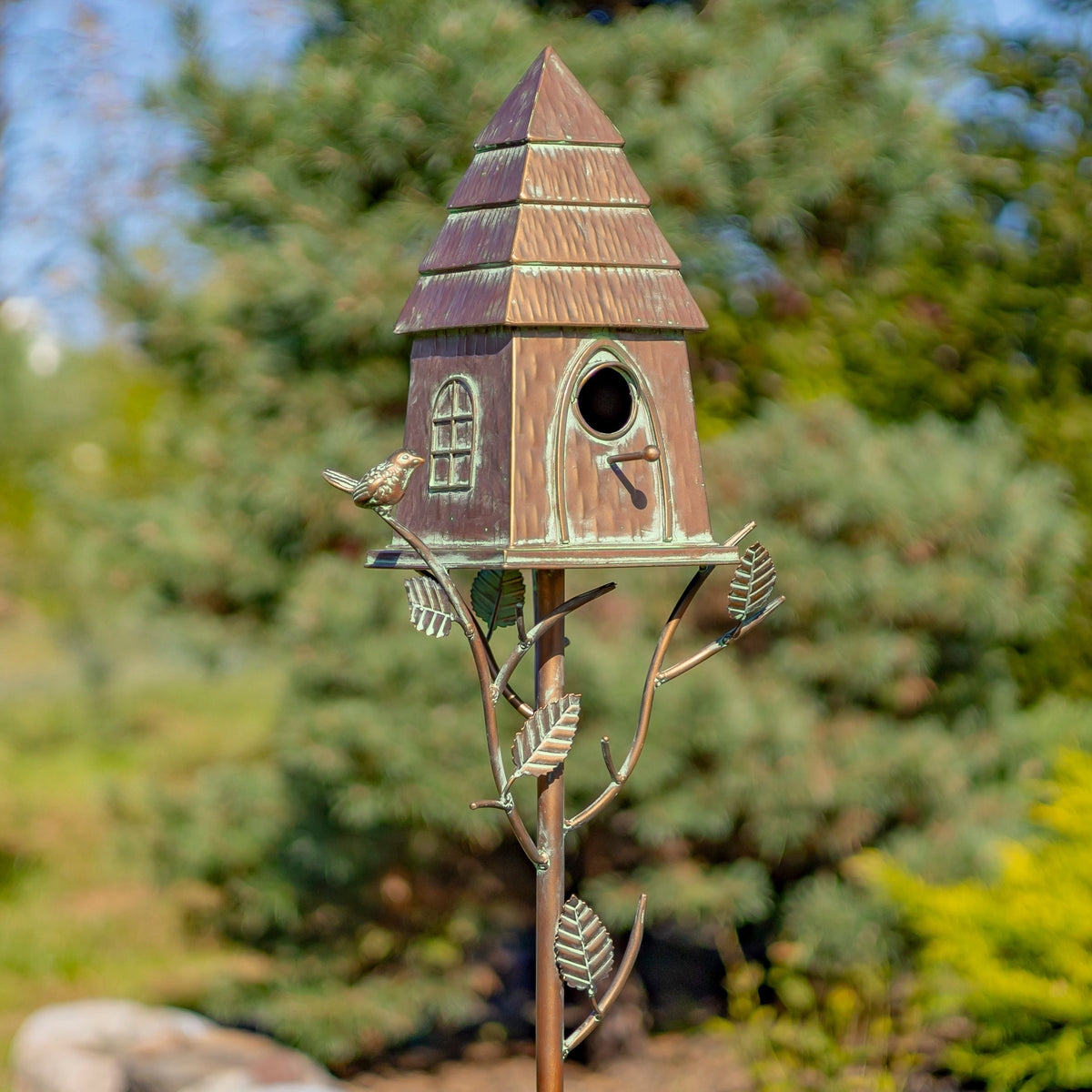 Decorative birdhouse on a stand with a natural background