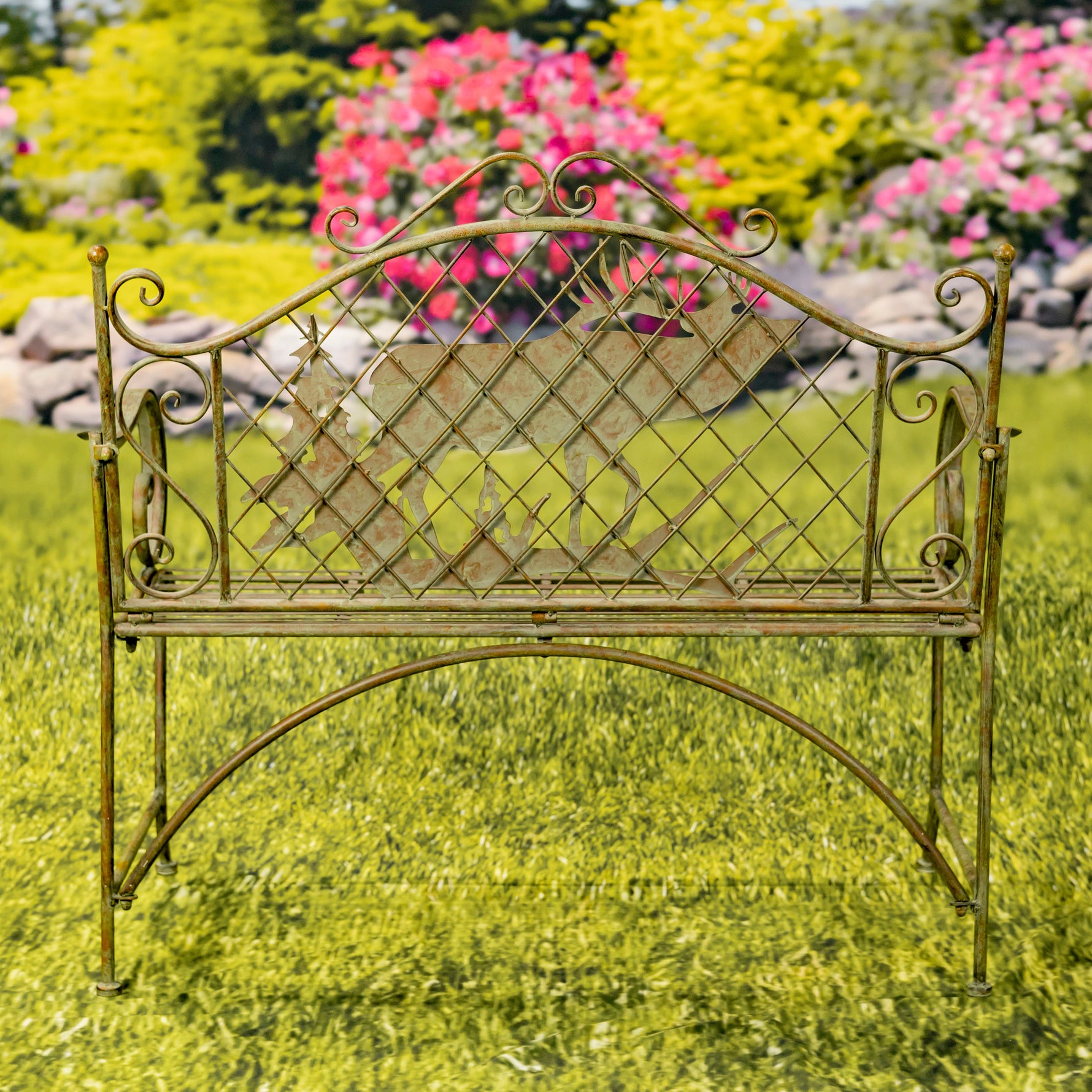 Decorative metal bench in a garden setting with flowers and rocks in the background