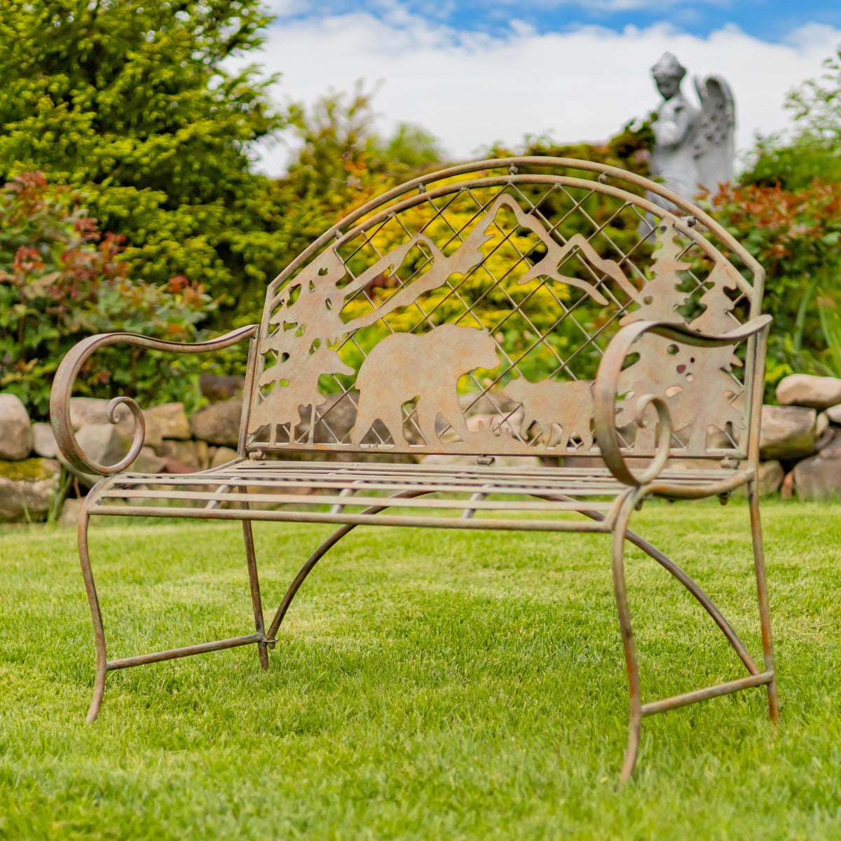 Decorative metal bench with animal cutouts in a garden setting