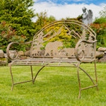 Decorative metal bench with animal cutouts in a garden setting