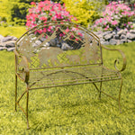 Decorative metal bench with bear and cub design in a garden setting