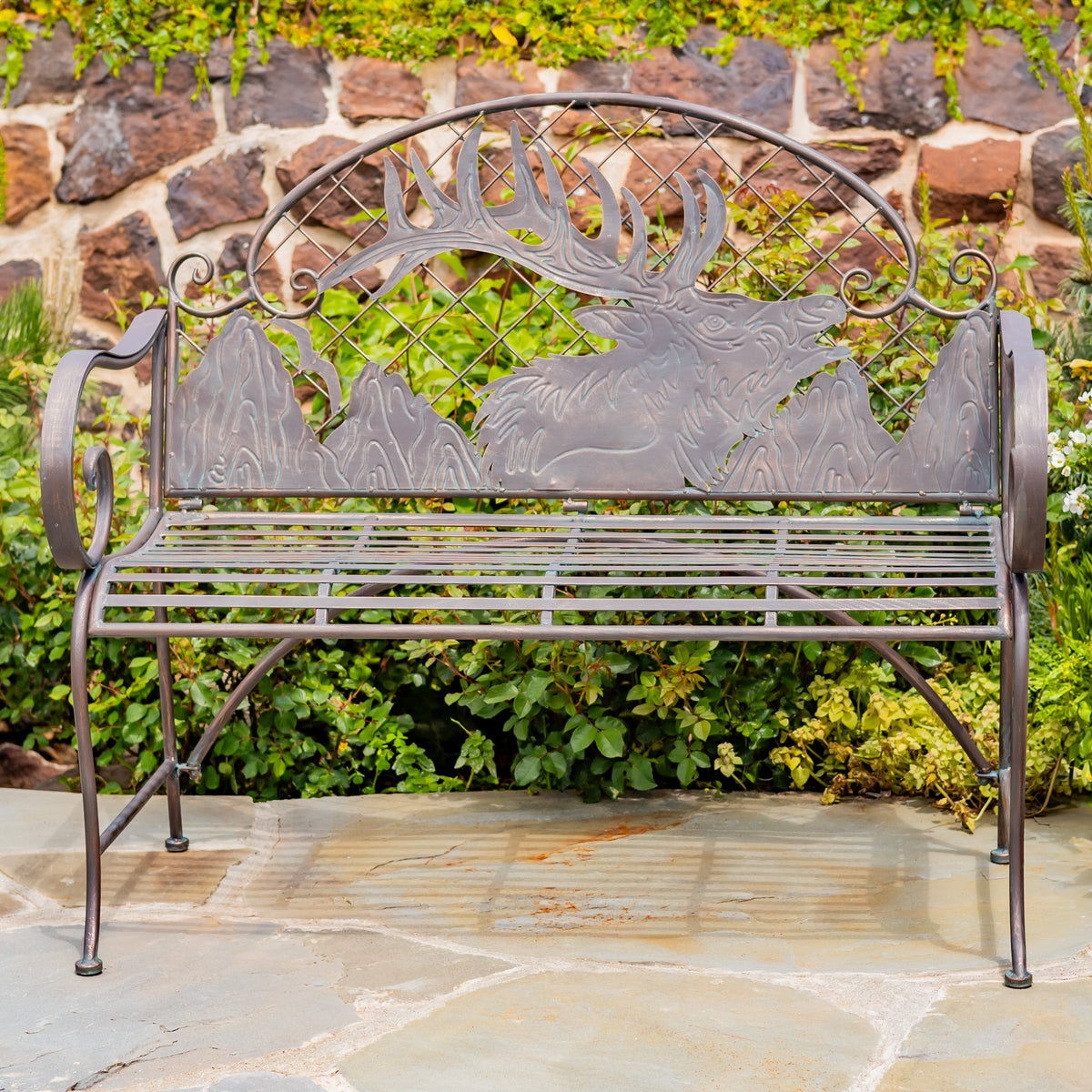 Decorative metal bench with elk design in a garden setting