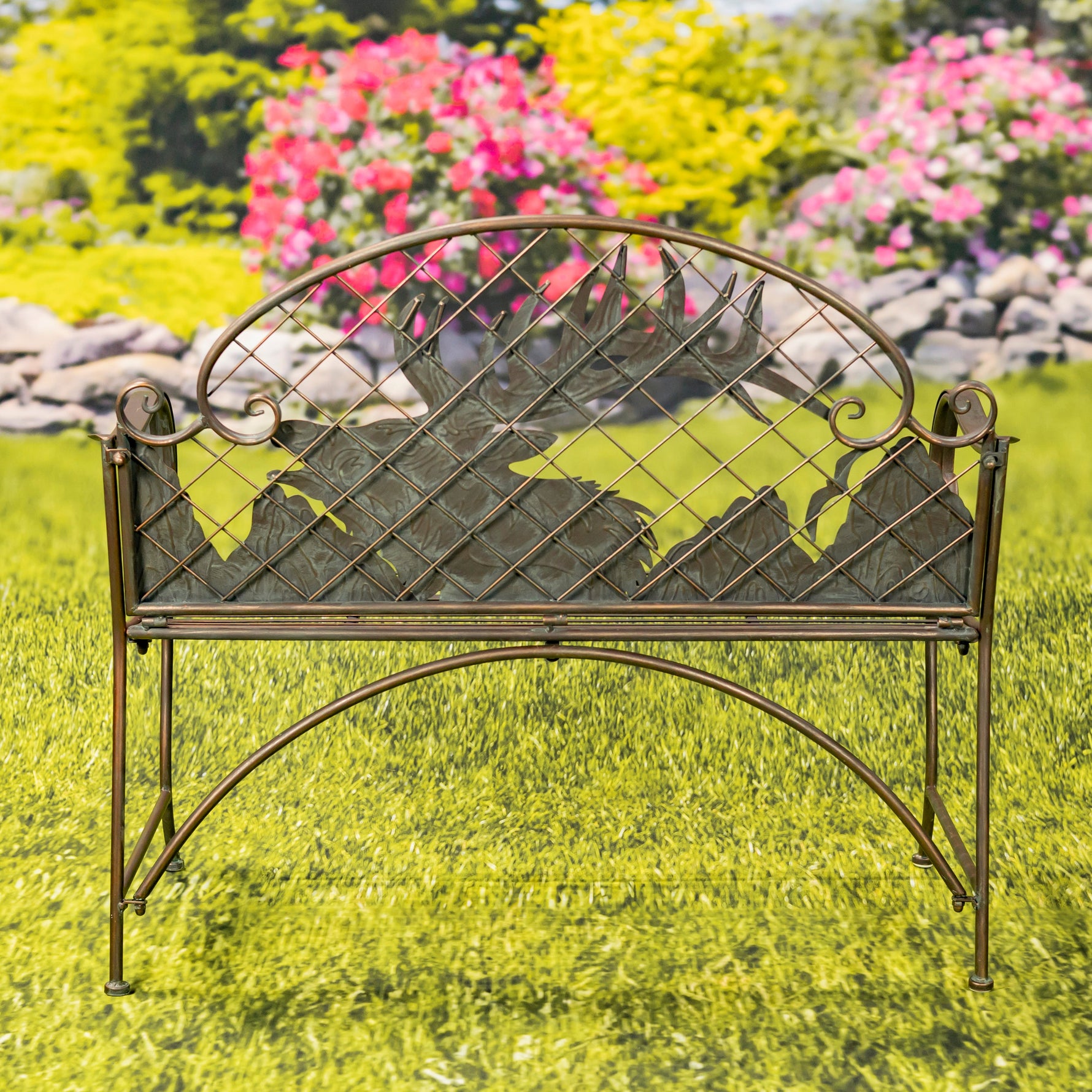 Decorative metal bench with leaf design in a garden setting