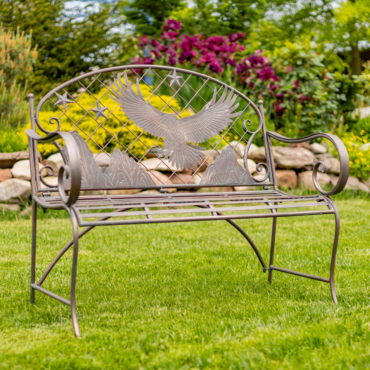 Decorative metal bench with eagle design in a garden setting