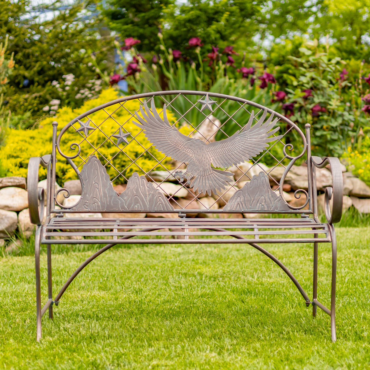 Decorative metal bench with eagle design in a garden setting