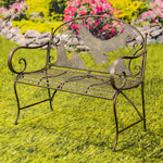 Decorative metal bench with eagle design on a grassy area with flowers in the background