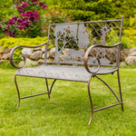 Decorative metal bench with animal cutouts in a garden setting