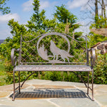 Decorative metal bench with wolf design in a garden setting