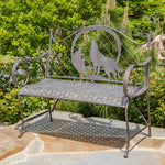 Decorative metal bench with wolf design in a garden setting