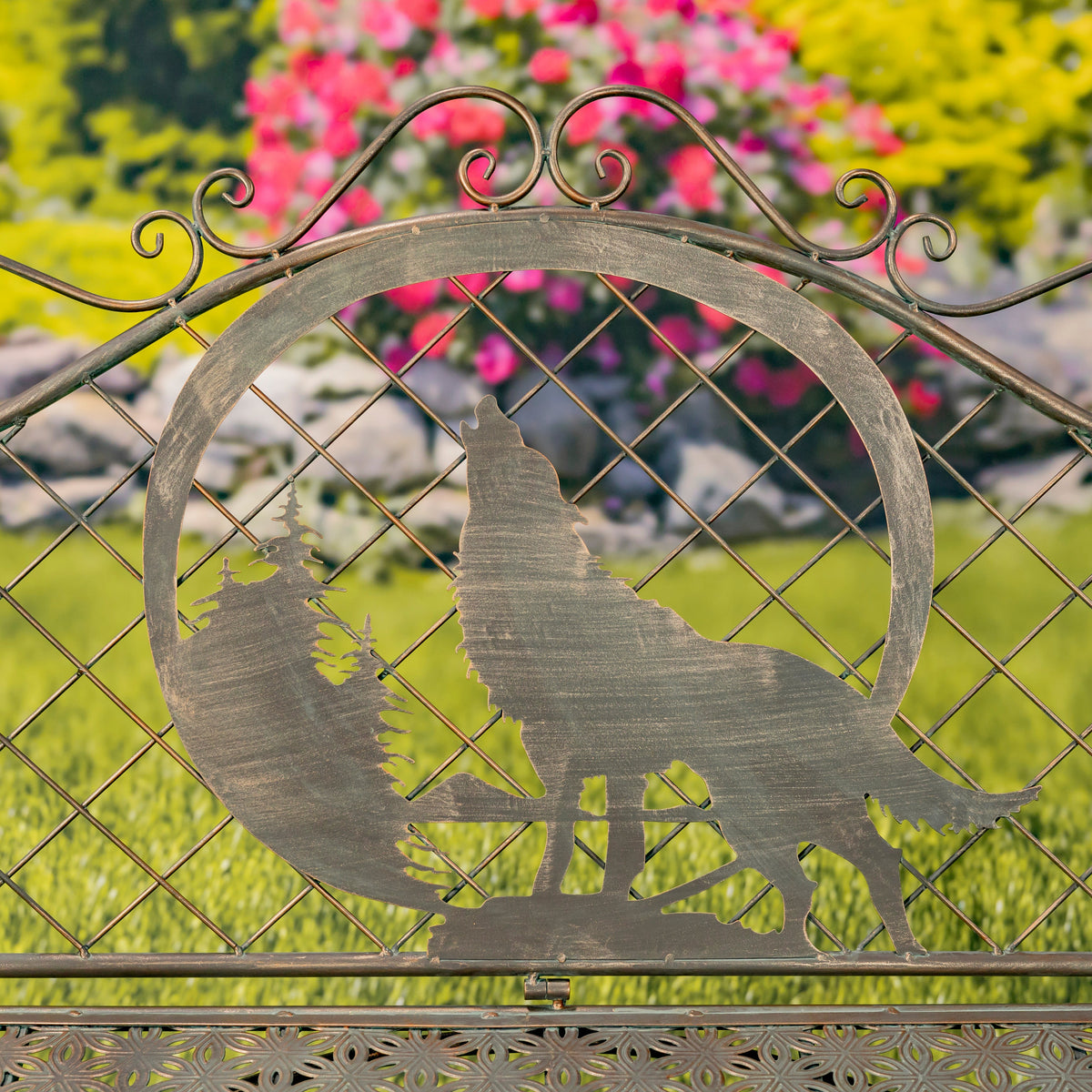 Decorative metal gate with wolf silhouette in a garden setting
