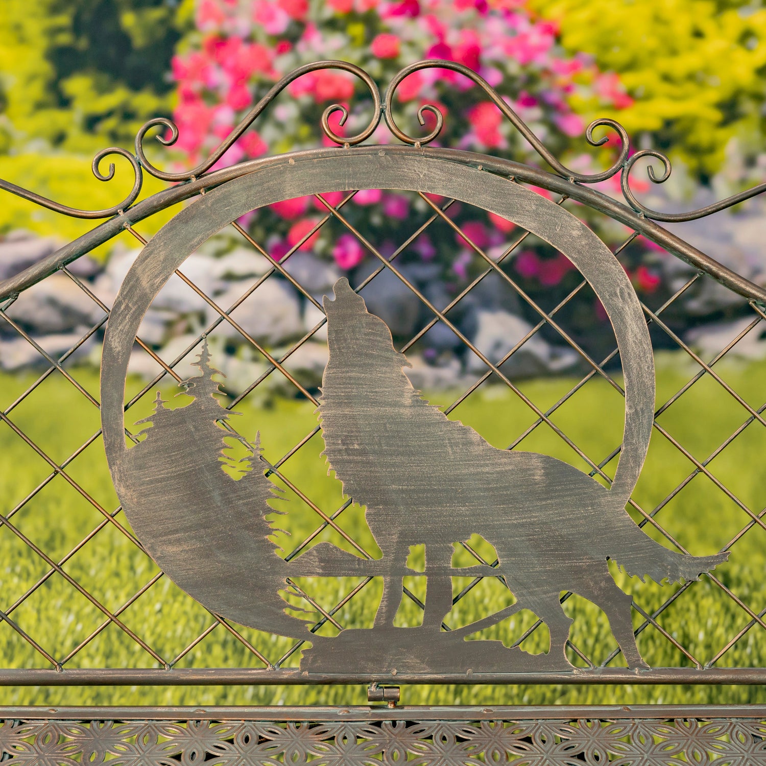 Decorative metal gate with wolf silhouette in a garden setting