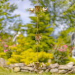 Decorative metal hanging with birds and flower pots against a garden background
