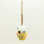 Decorative birdhouse with floral and dragonfly design on a white background