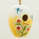 Decorative ceramic birdhouse with floral and dragonfly design on a white background