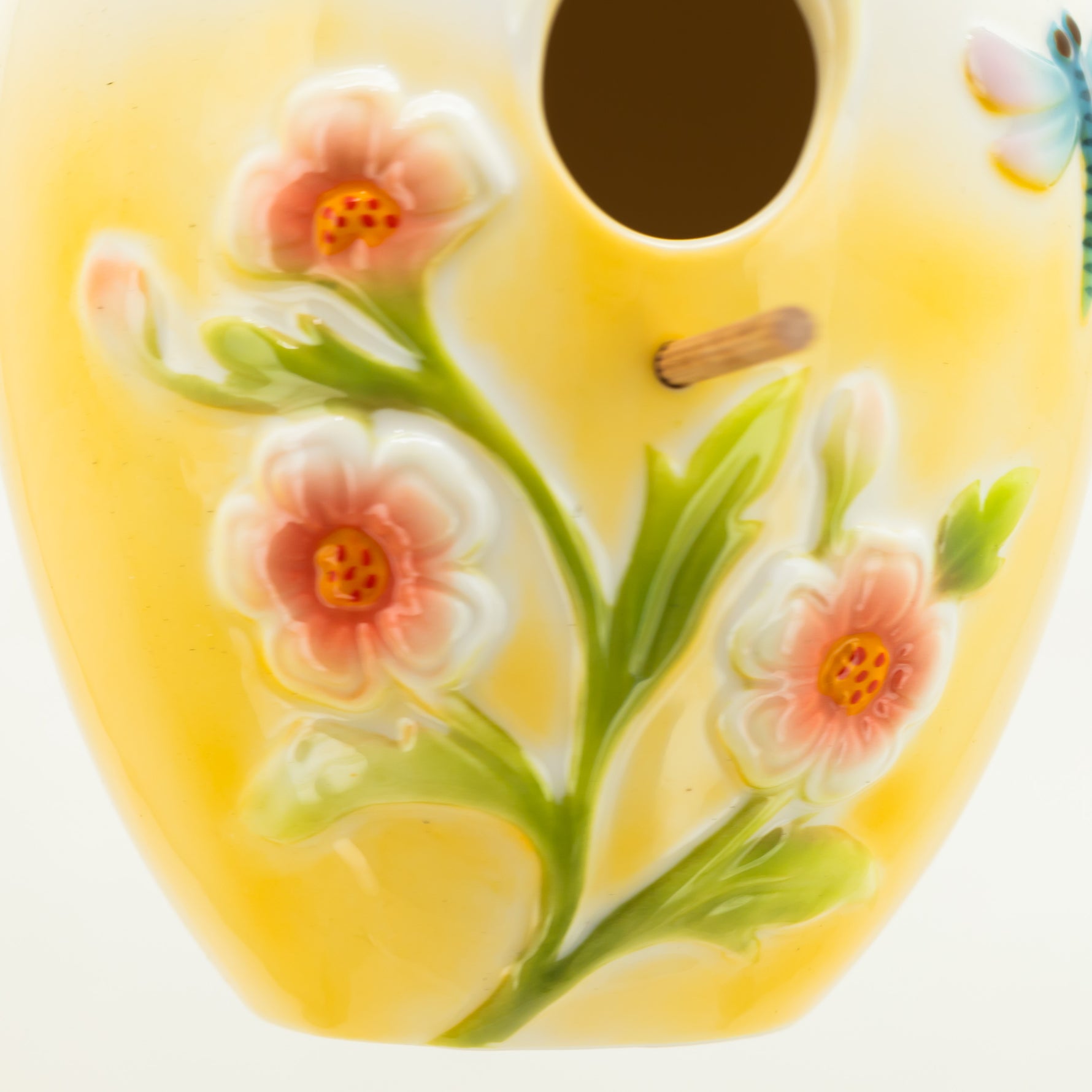 Decorative ceramic item with floral design on a yellow background