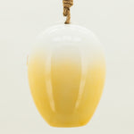 Yellow glass vase with a white top on a light gray background