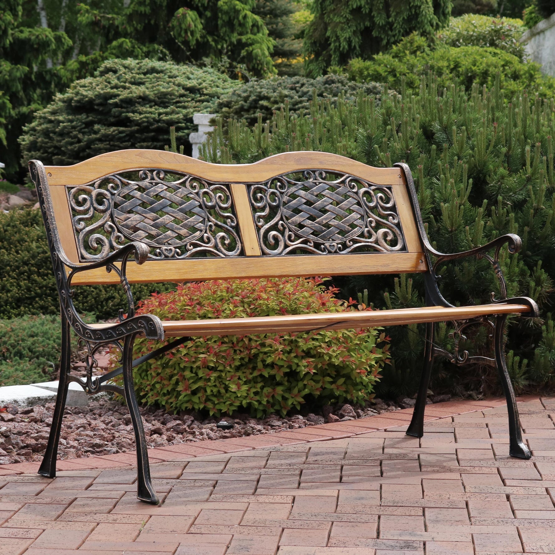 Bench sitting on brick pathway with bushes in the background