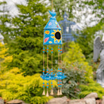 Colorful wind chime with floral designs against a garden background