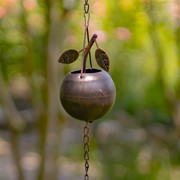 Decorative hanging planter with leaves against a blurred natural background