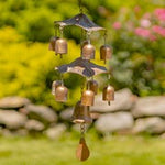Decorative wind chime with bells in a garden setting