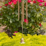 Bell hanging from a string with a blurred floral background