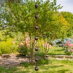 Decorative hanging orbs in a garden setting