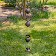 Decorative hanging with ceramic balls on a grassy background