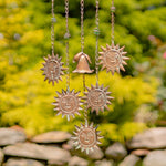 Decorative hanging sun and bell ornaments with a natural background