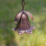 Bronze bell-shaped object on a blurred green background