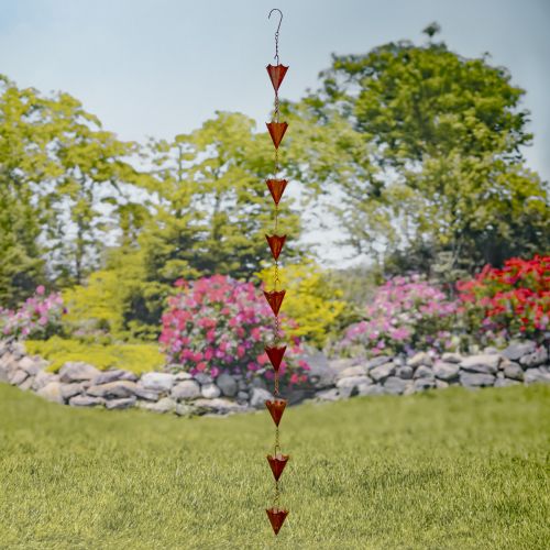 Decorative wind chime with triangular shapes in a garden setting