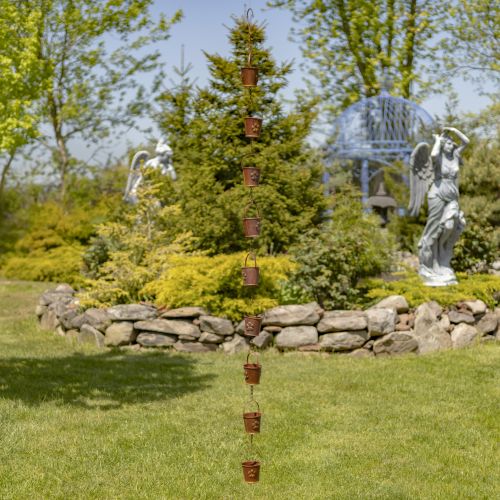 Decorative rain chain in a garden setting with statues and greenery